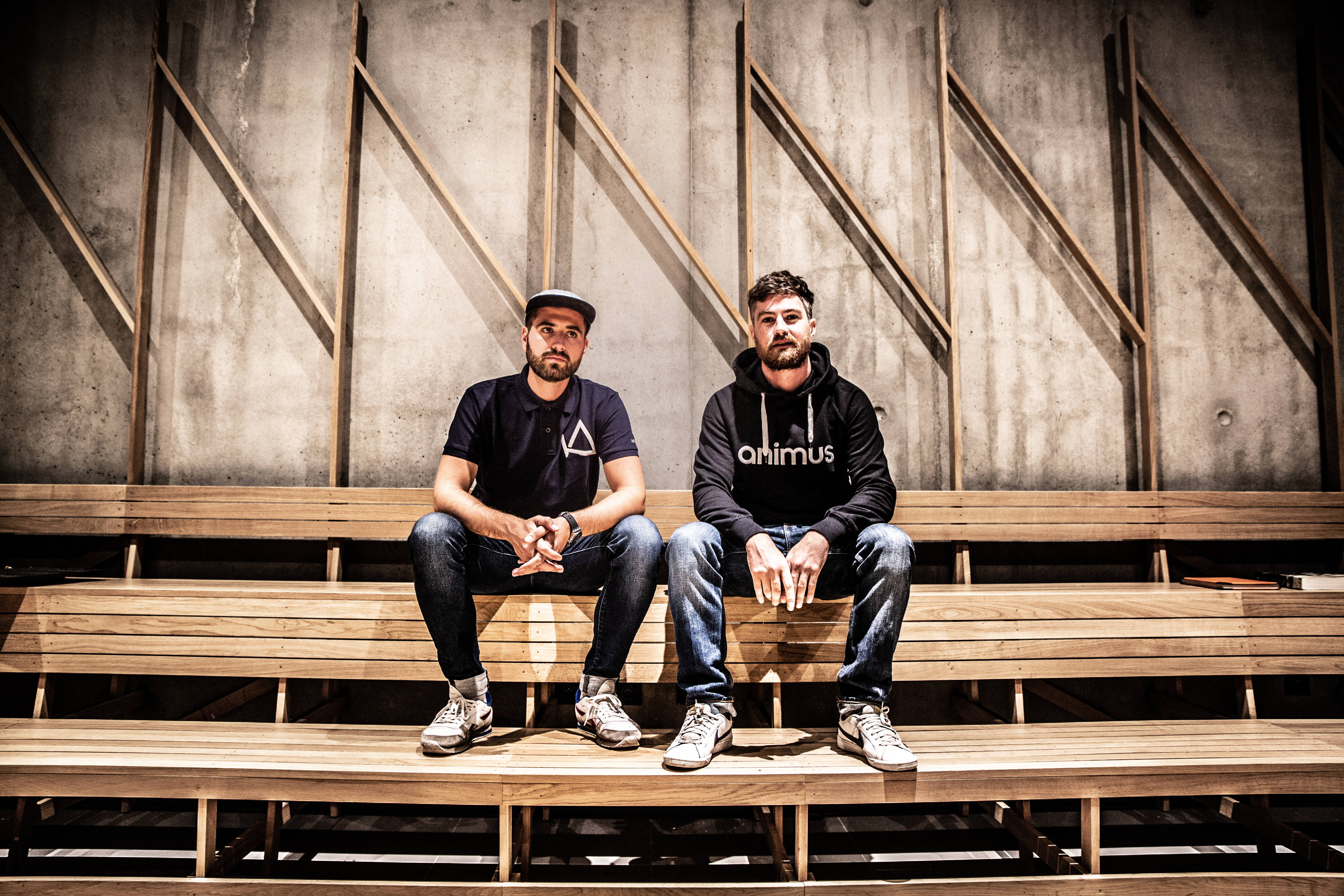 deux hommes assis sur un banc de bois